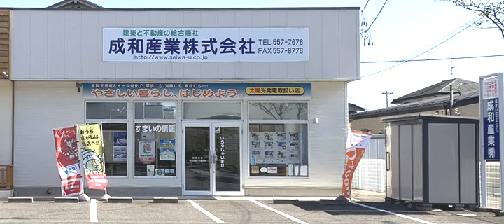 成和産業の店舗外観と前面の駐車スペース